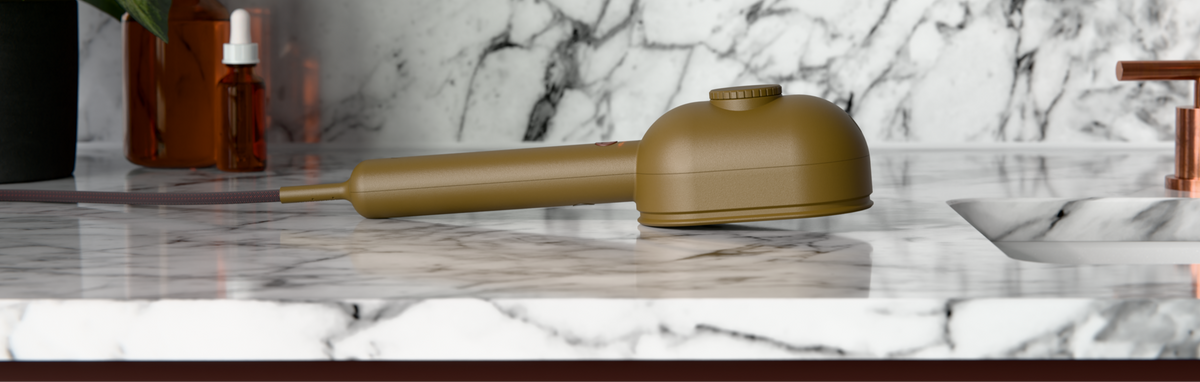 Mimi ultrasonic moisturiser on marble countertop with hair oil